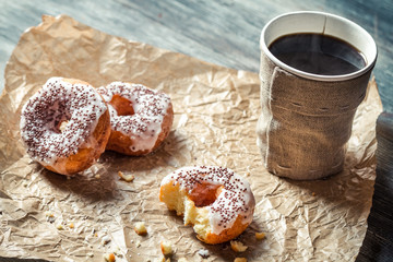 Closeup of hot coffee and donuts on paper