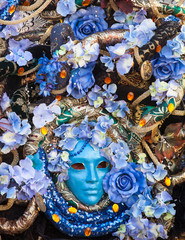 Bllue mask with floral decorations exhibited during the Carnival