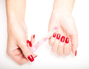 Girl hand manicure with nail file on bright background