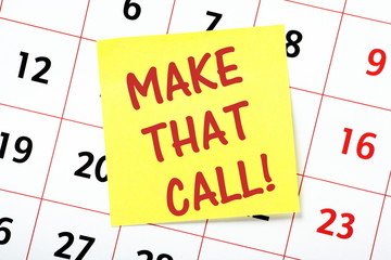 Make That Call reminder note posted on a wall calendar