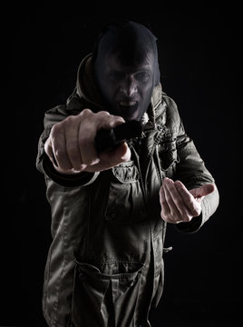 Robber pointing gun at camera