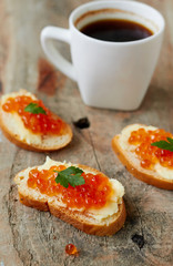 Canape with red caviar and cup of coffee