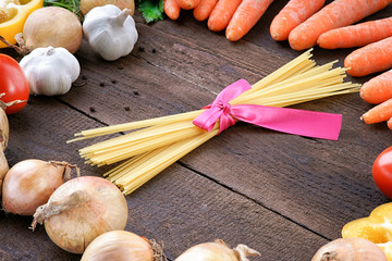 Pasta and vegetables on wooden table background