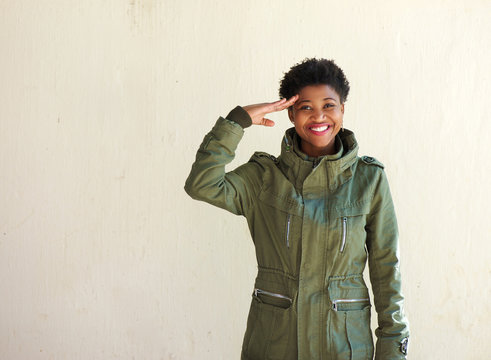 Young woman smiling and saluting
