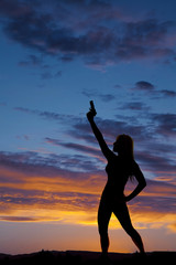 silhouette of a woman pointing a gun up