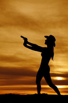 silhouette of woman cowboy hat with gun pointed side