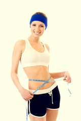 Young beautiful woman measuring waist with a tape measure