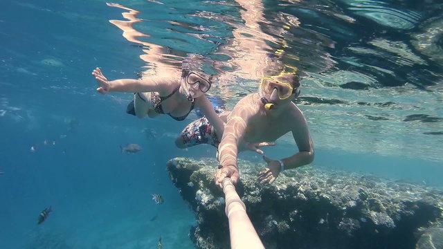 the couple dive with mask and make selfe under water