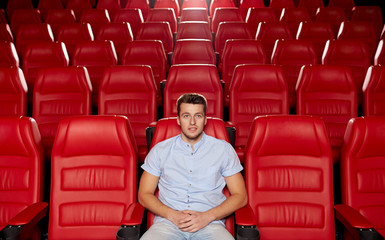 happy young man watching movie in theater