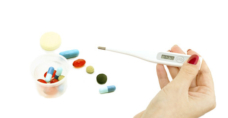 Electronic thermometer in hand and a variety of tablets