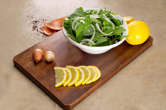 Rucola salad leaves with ingredients on a wooden plate