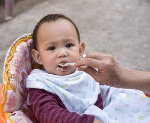 mother feeding  baby eating food by spoon