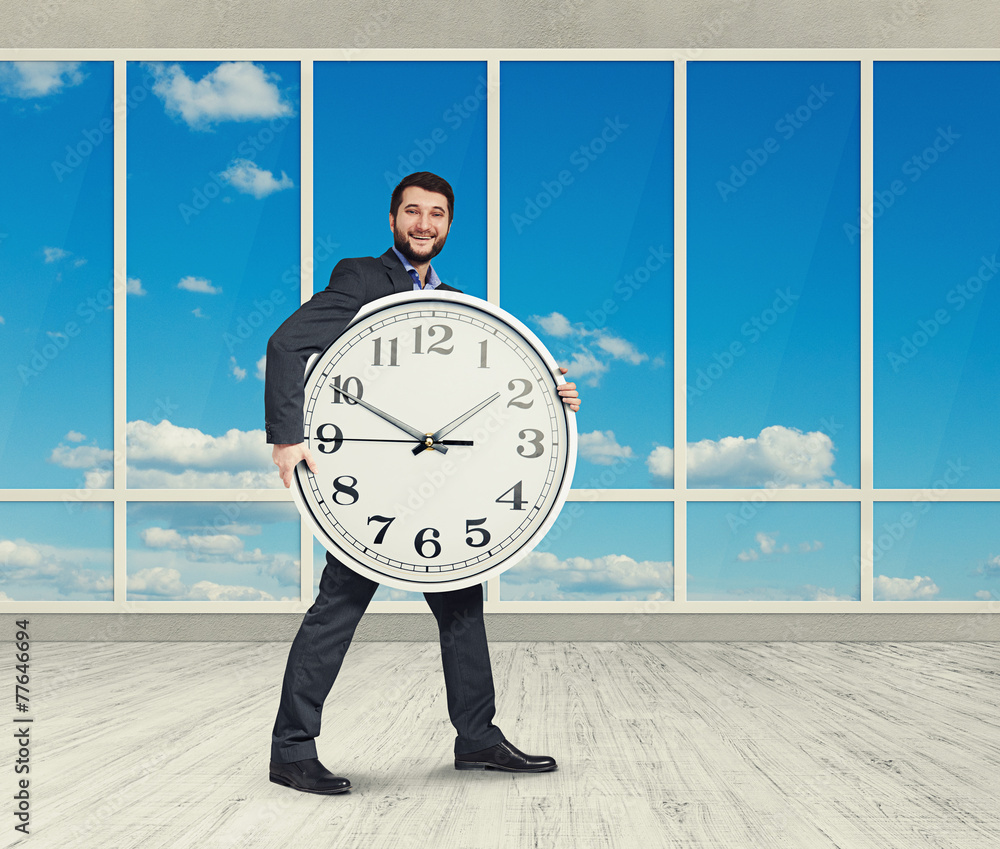 Wall mural man holding big clock and looking at camera