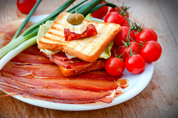 Sandwich with prosciutto, onion and cherry tomatoes