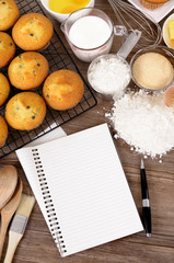 Fresh muffin cup cake making cooking preparing with blank notebook or recipe book and kitchen equipment background photo