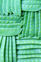 Young green peas in pods background
