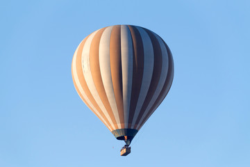 A hot air balloon flying on a clear sky day.