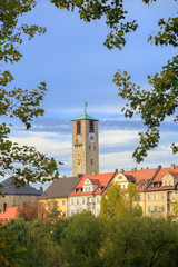 City tower with clock and old buildings, trees