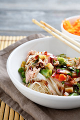 Rice noodles with peas and onions in a white bowl