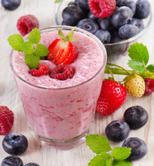 Raspberry smoothie with fresh berries on  wooden table .