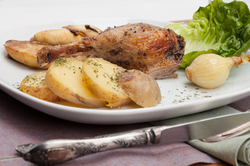 Roast leg of duck with potatoes and fried apples.