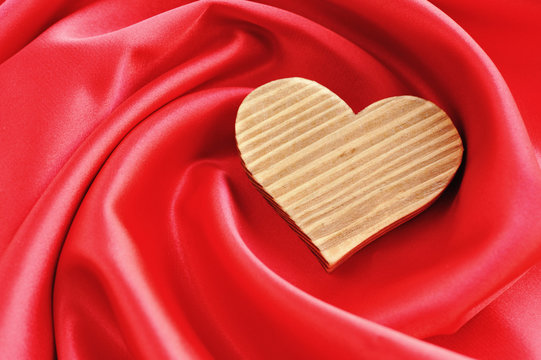 Wooden Heart on red satin background