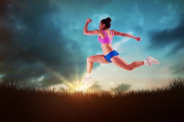 Fototapeta na wymiar Composite image of fit brunette running and jumping