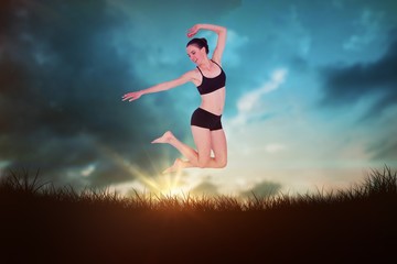 Plakat Composite image of full length of a sporty young woman jumping