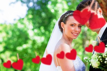 Composite image of loving bride and groom in garden