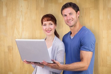 Composite image of couple using a laptop together