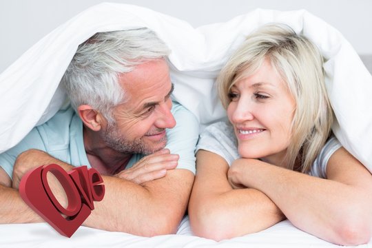 Composite image of closeup of a mature couple lying in bed