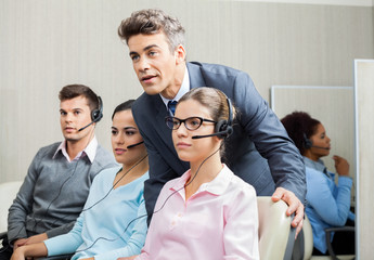 Manager Explaining To Employee In Call Center