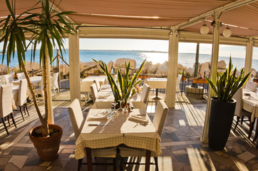 Table in a shade of a seafood restaurant at Piran harbor, Istria
