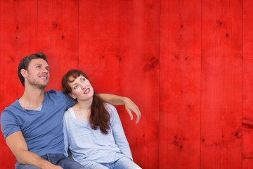Composite image of couple sitting on floor together