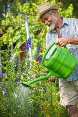 Senior man with a watering can © Alexander Raths