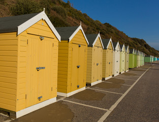 Gold and green beach huts in a row English seaside