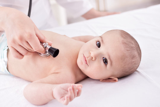 The doctor examining baby with stethoscope
