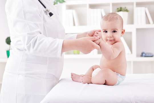 Doctor with baby doing  exercises