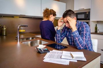 Desperate young couple with debts reviewing their bills