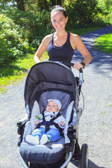 A Young mother jogging with a baby buggy