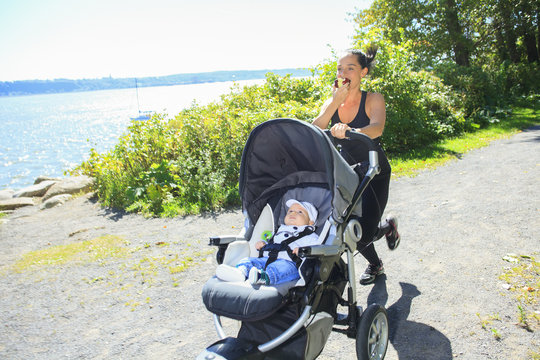 A Young mother jogging with a baby buggy