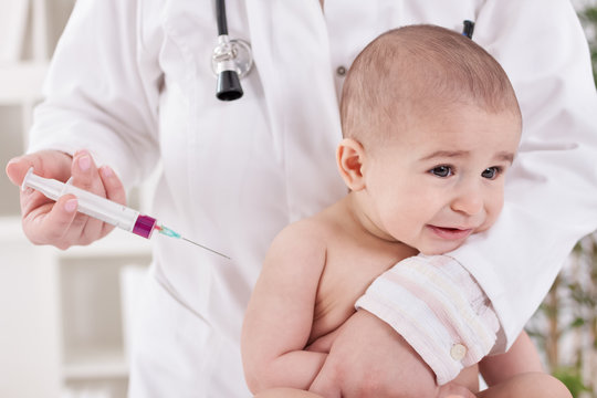 Sad baby receiving vaccine