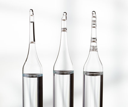 Three ampoules on light background