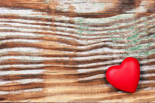 Red heart on grunge wooden background