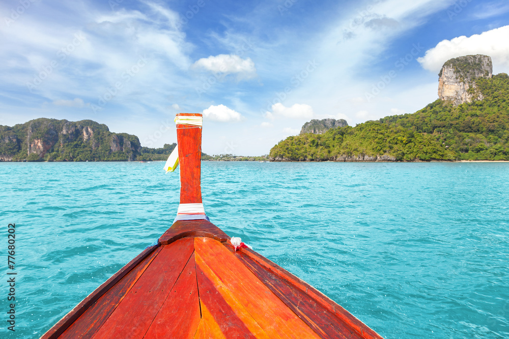 Wall mural wooden boat bow with tropical island in distance, thailand.