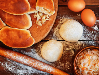 Traditional pies with cabbage. Dough, rolling pin and pastry on