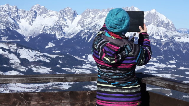Woman hiker taking photo with digital tablet, Alps