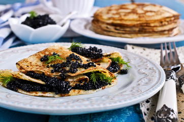 A stack of pancakes with black caviar