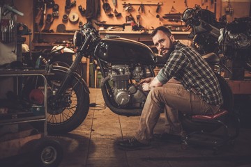 Mechanic building vintage style cafe-racer motorcycle 