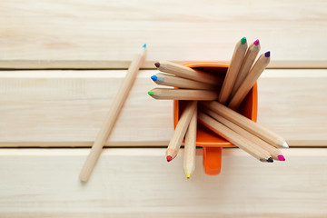 Obraz premium Cup with colorful Pencils on wooden table